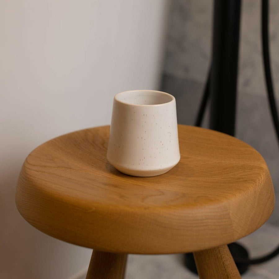 Elegant ceramic cups arranged neatly on a polished wooden table, perfect for morning coffee or tea rituals.