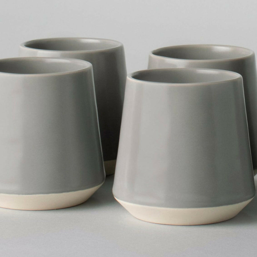 Elegant ceramic cups arranged neatly on a polished wooden table, perfect for morning coffee or tea rituals.
