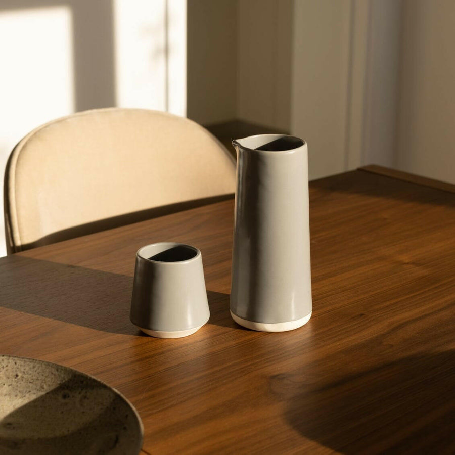 Elegant ceramic cups arranged neatly on a polished wooden table, perfect for morning coffee or tea rituals.