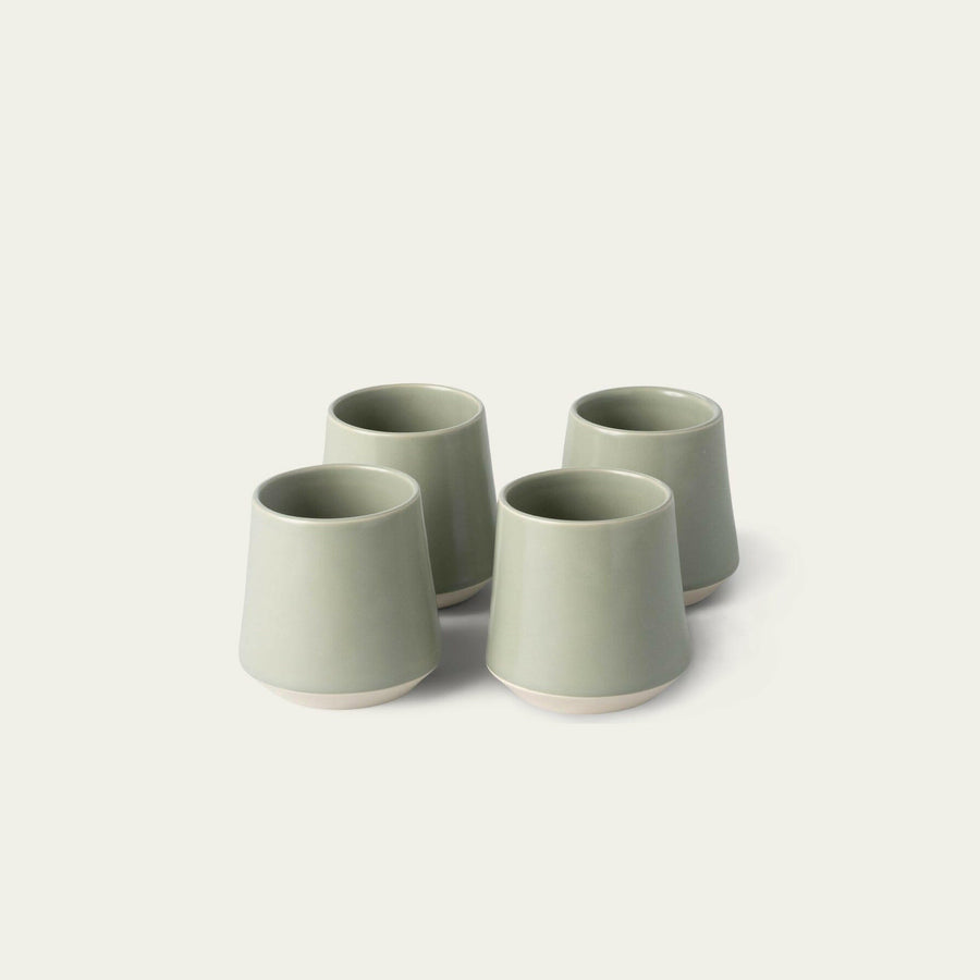 Elegant ceramic cups arranged neatly on a polished wooden table, perfect for morning coffee or tea rituals.