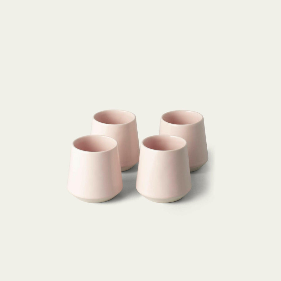 Elegant ceramic cups arranged neatly on a polished wooden table, perfect for morning coffee or tea rituals.