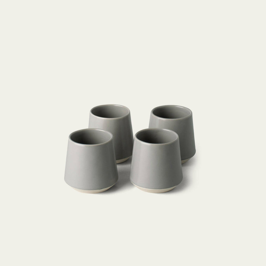 Elegant ceramic cups arranged neatly on a polished wooden table, perfect for morning coffee or tea rituals.