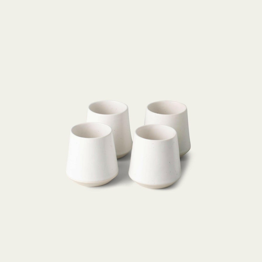 Elegant ceramic cups arranged neatly on a polished wooden table, perfect for morning coffee or tea rituals.