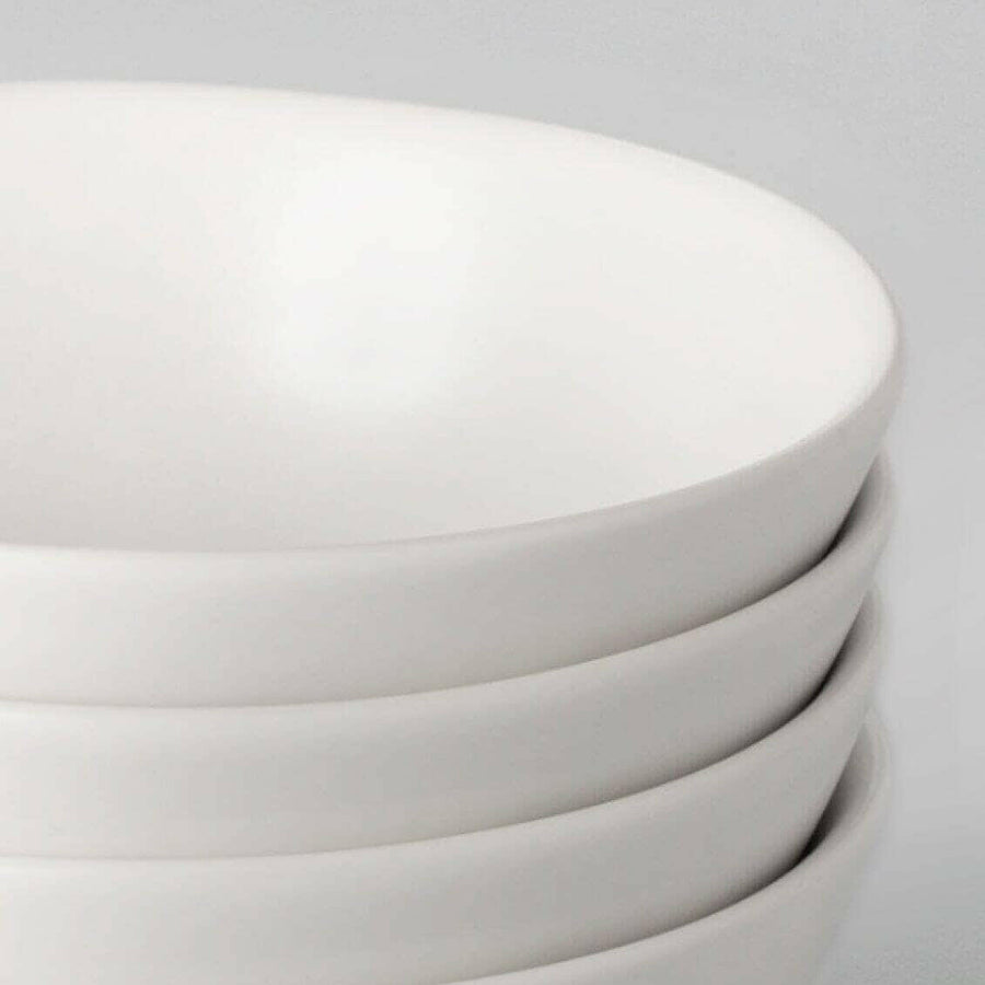 Elegant white porcelain dinnerware set featuring plates and bowls, perfect for formal dining occasions